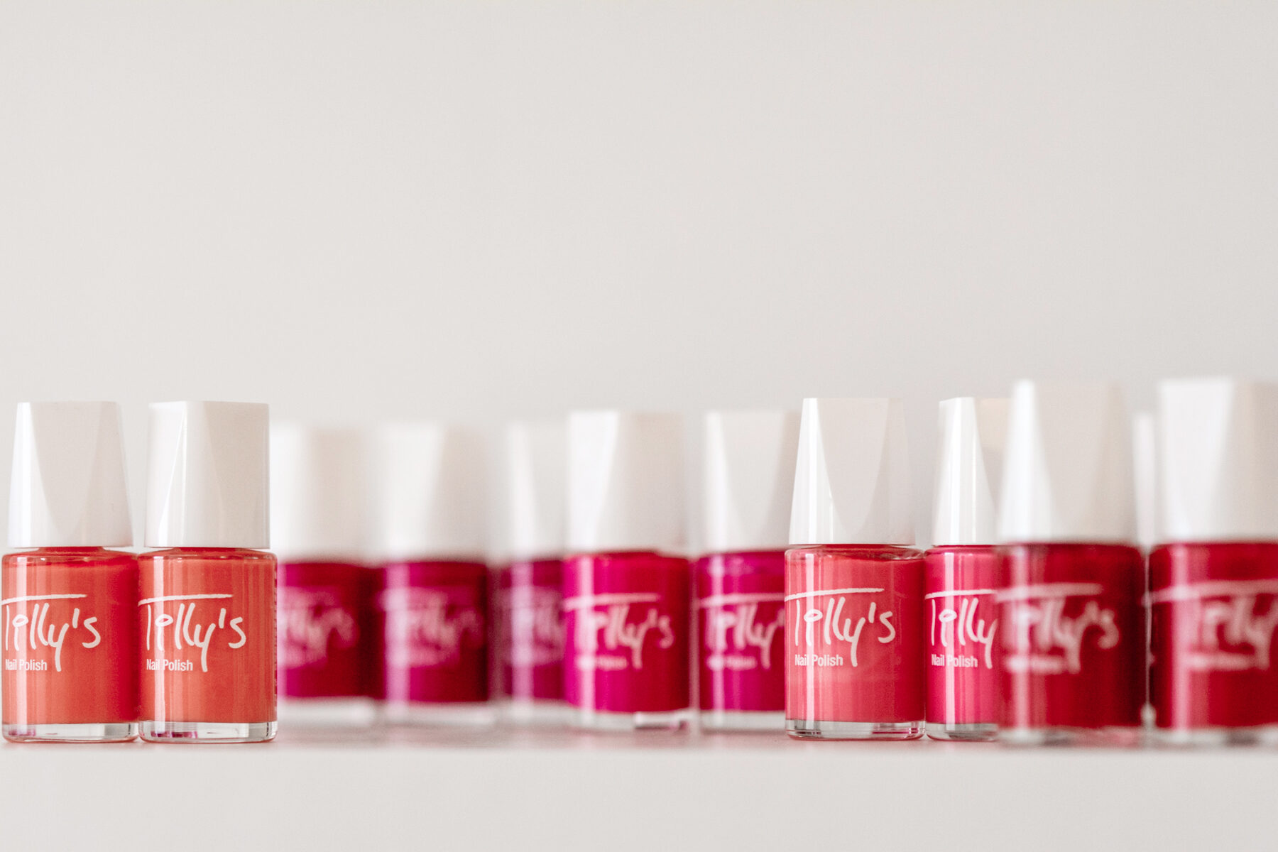 Rij flesjes nagellak in rood en roze