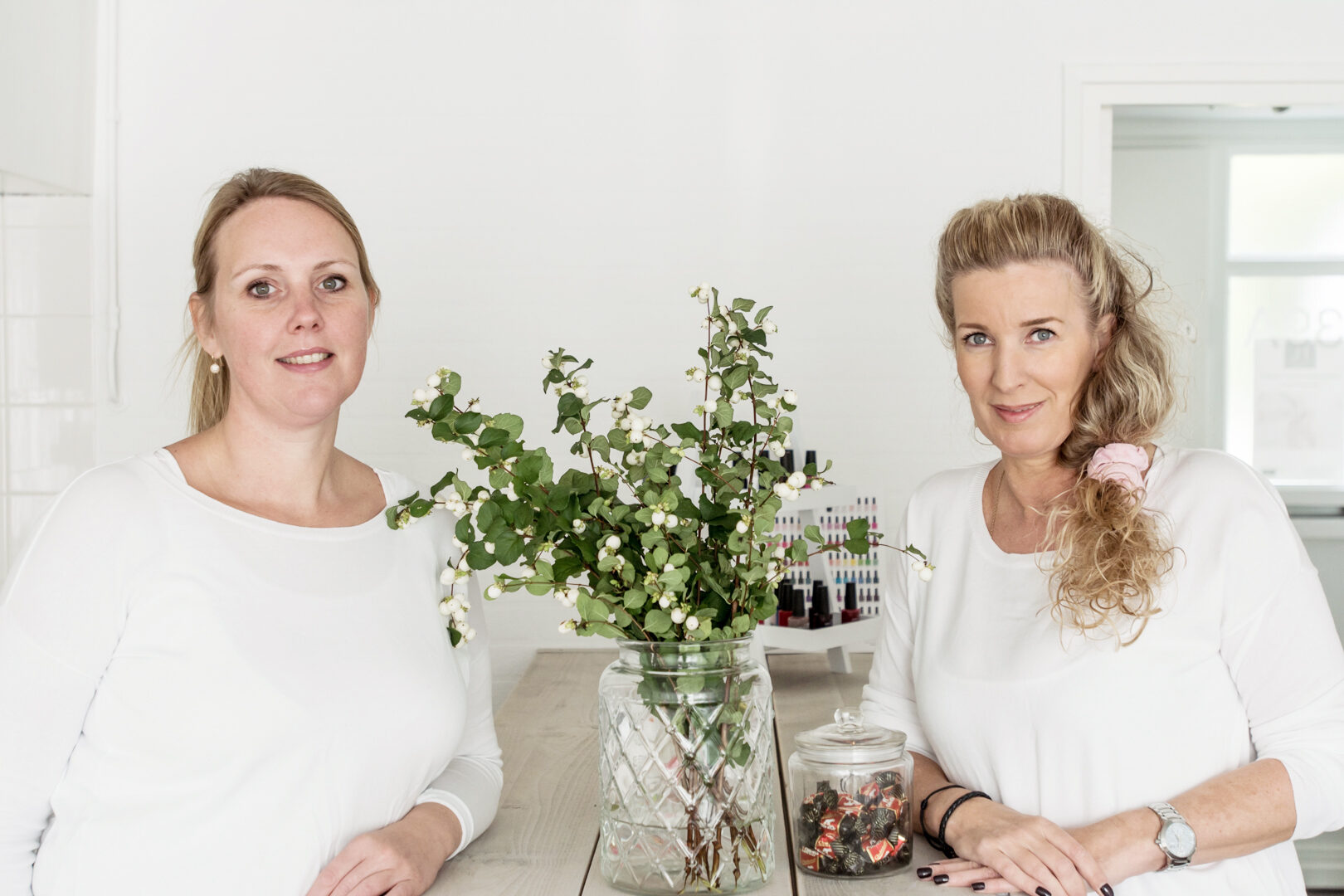 Twee pedicures van de praktijk aan tafel met bloemen